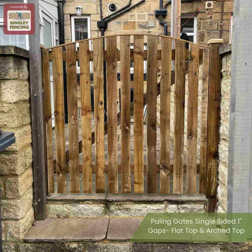 A Bingley Fencing Paling Gates Double Sided with 2" gaps and an arched top stands between two stone pillars. Vertical slats are evenly spaced for style and durability. The sign reads: "Flat Top & Arched Top.