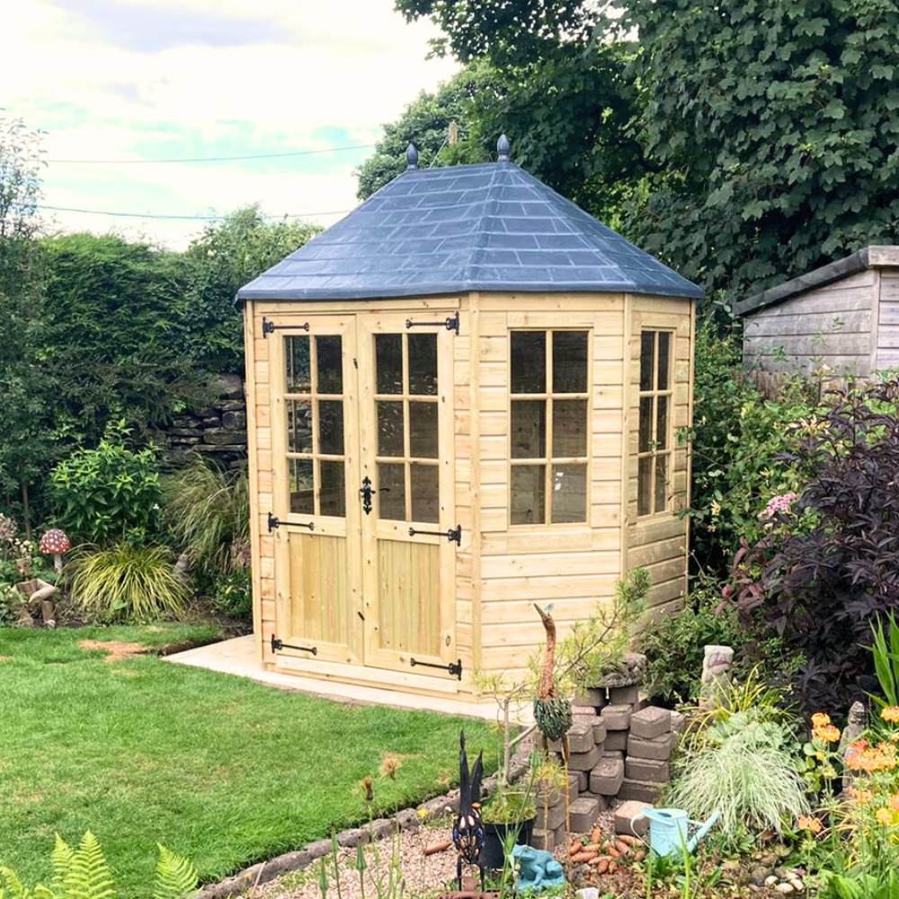 Octagonal Shaped summerhouse with fibreglass roof. Installed in a garden with trees and flowers
