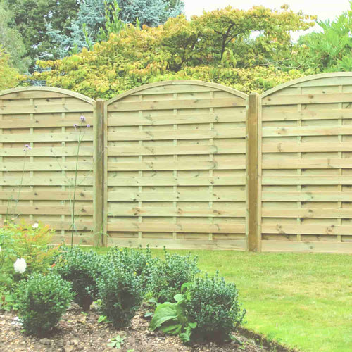 The KDM Arched Horizontal Fence Panel (AH180) adds stylish privacy to your yard, perfectly complementing green grass, shrubs, and leafy trees in a well-maintained landscape.