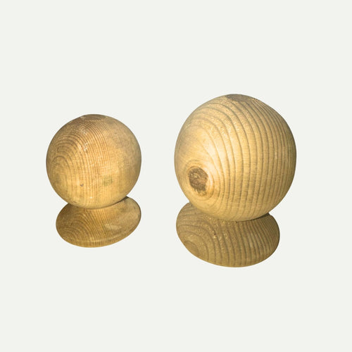 Two round, unfinished KDM Ball Finial wooden spheres—each mounted on a flat wooden base—are displayed against a plain white background. Ideal as classic fence post finials, they perfectly complement your decking accessories or outdoor spaces constructed with pressure treated timber.