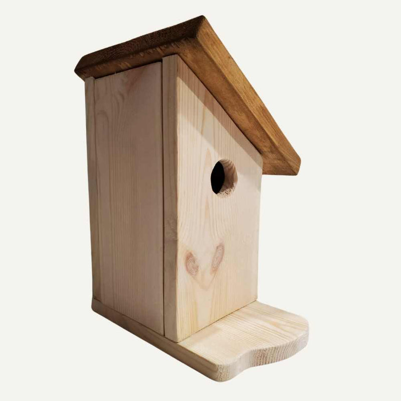 Load image into Gallery viewer, The Bingley Fencing Tall Bird House is a handmade birdhouse featuring a slanted roof, round front entrance, and small flat perch, shown at an angle against a plain background.