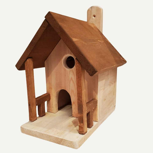 The Bingley Fencing Bird House features a slanted roof, round entrance, arched doorway, and a small veranda—all handcrafted from natural wood for unique charm.