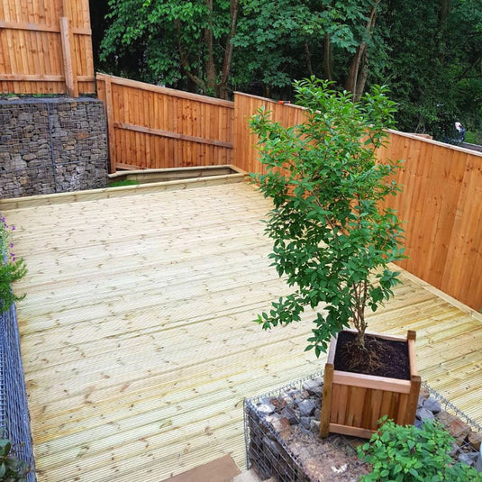 Elevated garden decking platform with wooden fencing and plants