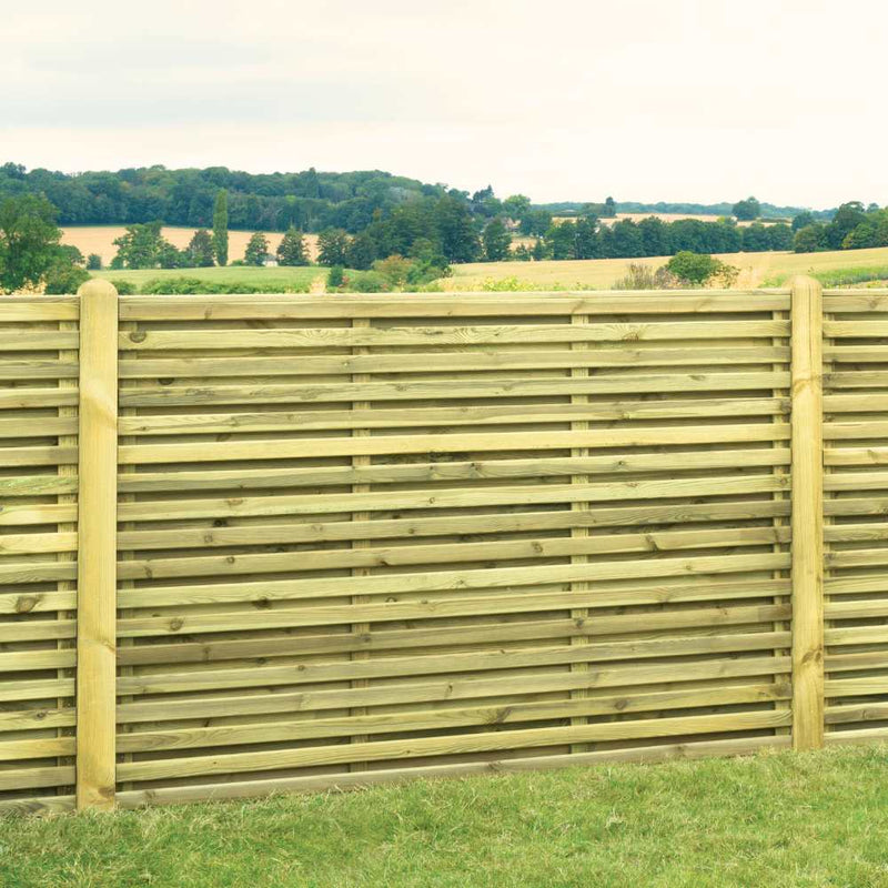 Load image into Gallery viewer, The KDM Double Sided Slatted Panels (SDS180) stand on grassy ground, with rolling green hills, trees, and fields in the background under a cloudy sky.
