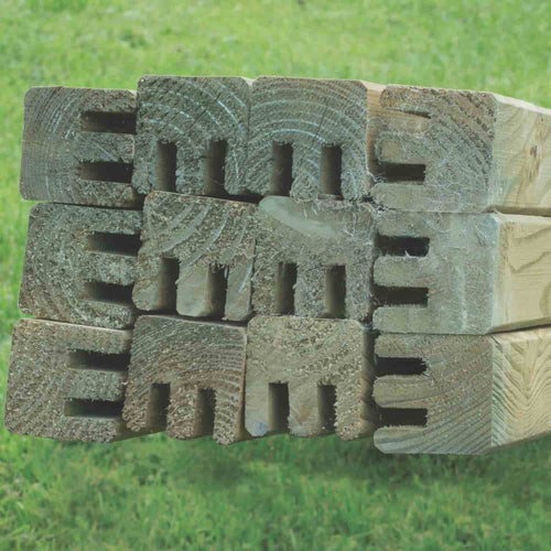 A close-up of KDM’s Fence Panel Repair Kit Framing Double Groove (RK-DGF): stacked framing posts with double grooves, neatly arranged on grass—perfect for repairing fences in West Yorkshire projects.