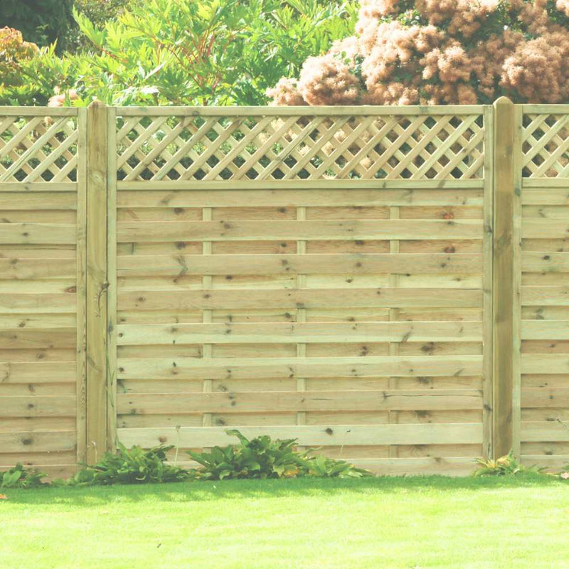 Load image into Gallery viewer, The KDM Horizontal Lattice Fence Panel (HLT) features a wooden design with a lattice top, made from pressure-treated timber, and is set amidst green grass, vibrant plants, trees, and bushes.