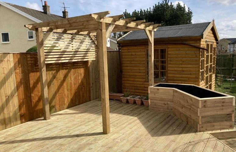 Wooden decking area with timber pergola , shed and custom planters