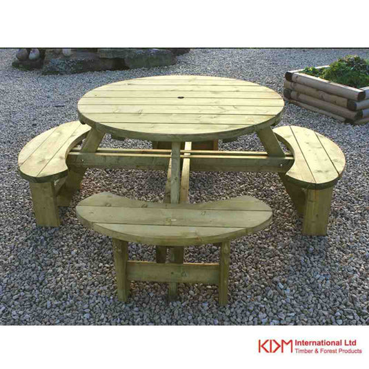 The Round Table & Bench Seat - RBS by KDM features a wooden round tabletop and four curved benches, ideal for garden dining on gravel. It includes an umbrella hole, with the KDM logo symbolizing quality timber garden products.