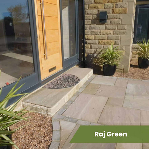 Front entrance with a light wooden door, stone step, patterned doormat, potted plants, stone wall, and tan-grey paving stones from the Bingley Fencing Indian Sandstone Paving Project Pack. Text overlay: Raj Green on a green banner.