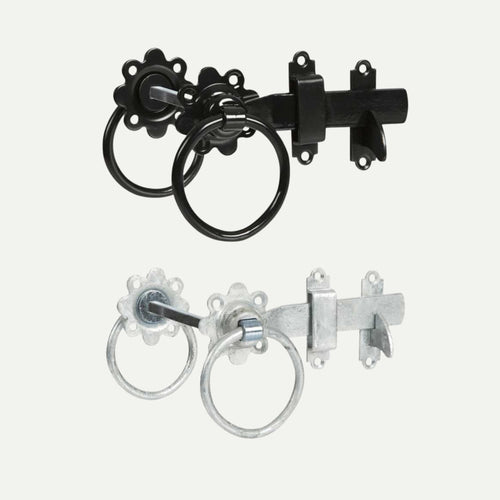 Two vintage-style door latches are displayed. The top latch, reminiscent of classic ironmongery, is the Henry Shaw Ring Gate Latch 6" in black with a round handle. The lower latch resembles a traditional gate fixture and is the galvanised version of the same Henry Shaw model, featuring the identical round handle. Both include decorative backplates with matching circular patterns.