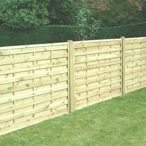 A tall KDM Square Horizontal Fence Panel (SH) lines the edge of a manicured lawn, with green shrubs and trees in the background.