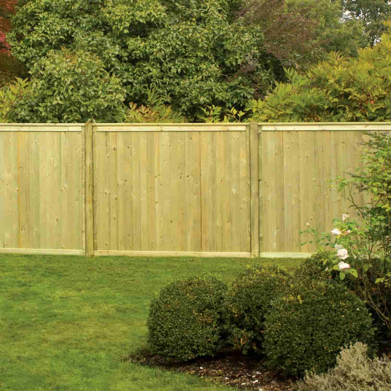 Load image into Gallery viewer, A KDM Tongue & Groove Fence Panels Flat Top (TGF) wooden privacy fence stands behind a neat lawn, with trimmed round shrubs and lush greenery in the background.