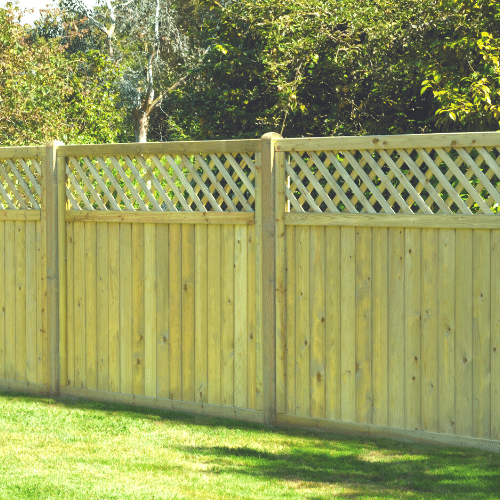 Load image into Gallery viewer, In a grassy yard, a KDM Tongue & Groove Lattice Top Fence Panel stands with a lush background of sunlit trees and foliage.