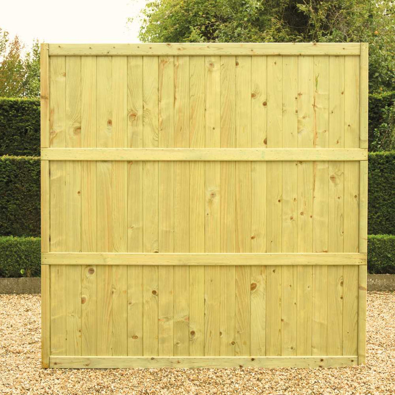 Load image into Gallery viewer, The KDM Tongue & Groove Fence Panels Flat Top (TGF) stand upright on gravel, framed by green hedges and trees. Vertical planks and horizontal beams deliver strong, private fencing for any outdoor area.