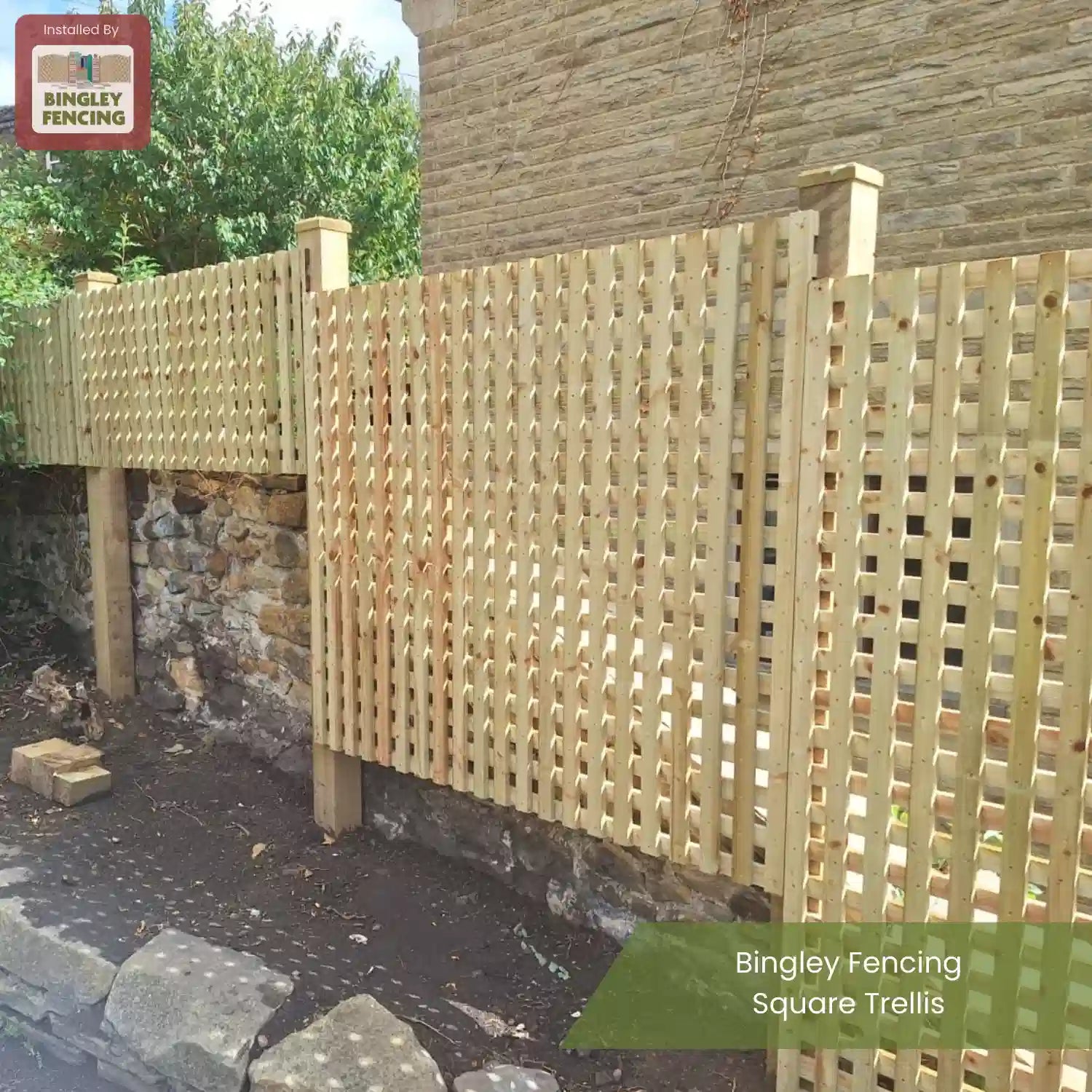 A wooden square trellis fence installed along a stone wall in a garden, with posts for support. Greenery is visible in the background. Text reads: Bingley Fencing Square Trellis.