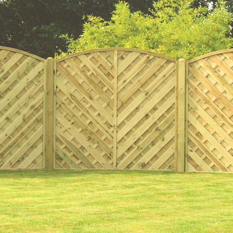 Load image into Gallery viewer, The KDM V Arched Solid European Fence Panel features a light brown finish and diagonal lattice design, shown installed on a well-kept green lawn with trees and shrubs in the background.
