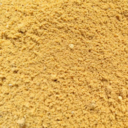Close-up of yellowish-brown textured powder, resembling Yellow Building Sand from Bingley Fencing, often used in bricklaying or landscaping projects, available in a 20kg bag.