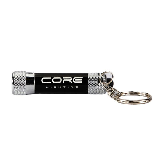 Introducing the Core Lighting Keyring Torch CLK15, a compact black LED torch featuring silver knurled ends and an attached key ring. The body proudly displays "CORE LIGHTING" in white text and offers a brightness of 15 lumens.