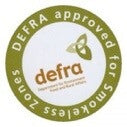 Load image into Gallery viewer, A round sticker in green and white showcases the text "DEFRA approved for Smoke-less Zones," making it perfect for use with Bingley Fencing's Newburn 25KG Smokeless Coal - Premium. The DEFRA logo, featuring a stylized leaf design and "defra" in lowercase, emphasizes the product's Clean Burning credentials.