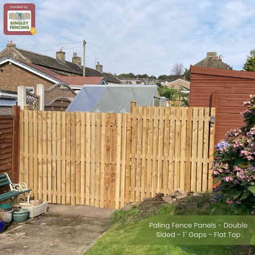 A garden displays Bingley Fencing’s Paling Fence Panels - Double Sided - 1 Gaps - Flat Top, bordered by sheds, houses, and plants. A corner sign reads “Installed by Bingley Fencing.”.