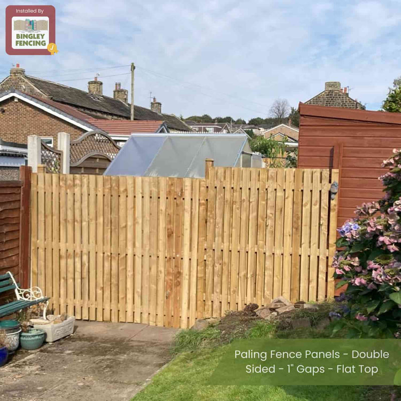 Load image into Gallery viewer, A garden displays Bingley Fencing’s Paling Fence Panels - Double Sided - 1 Gaps - Flat Top, bordered by sheds, houses, and plants. A corner sign reads “Installed by Bingley Fencing.”.