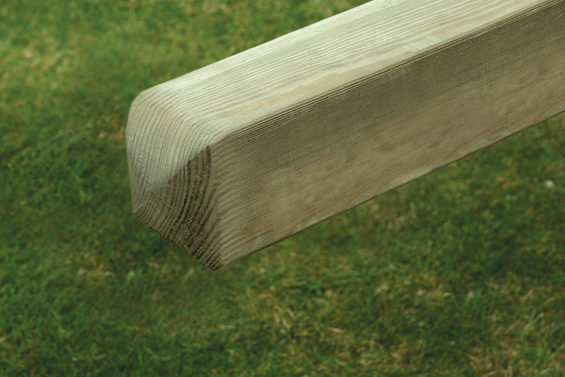Load image into Gallery viewer, A close-up of a KDM Smooth planed 4x4 (90mm x 90mm) European post with a chamfered end, positioned horizontally above grass. The grain and texture showcase its natural wood composition.