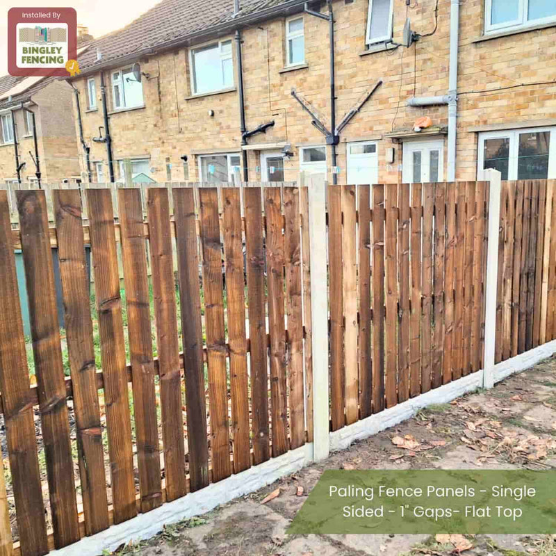 Load image into Gallery viewer, Paling Fence Panels - Single Sided - 1 Gaps - Flat Top by Bingley Fencing line the backyard edge of a brick house. These made-to-measure, pressure-treated panels feature a sign reading Installed by Bingley Fencing.