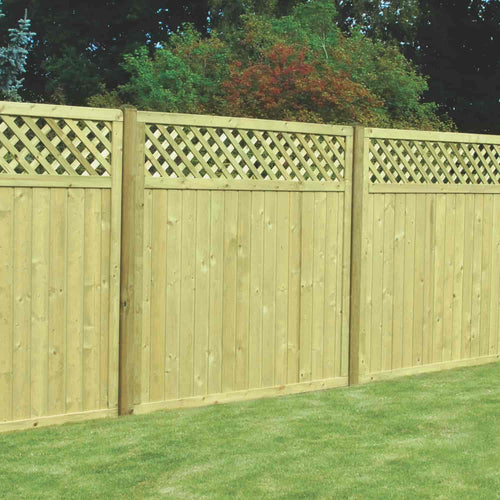 A KDM Reduced 5ft High Tongue & Groove Lattice Top Fence Panel (TGLT150) stands on a mowed lawn, featuring vertical panels with a lattice top and set against trees and bushes in the background.