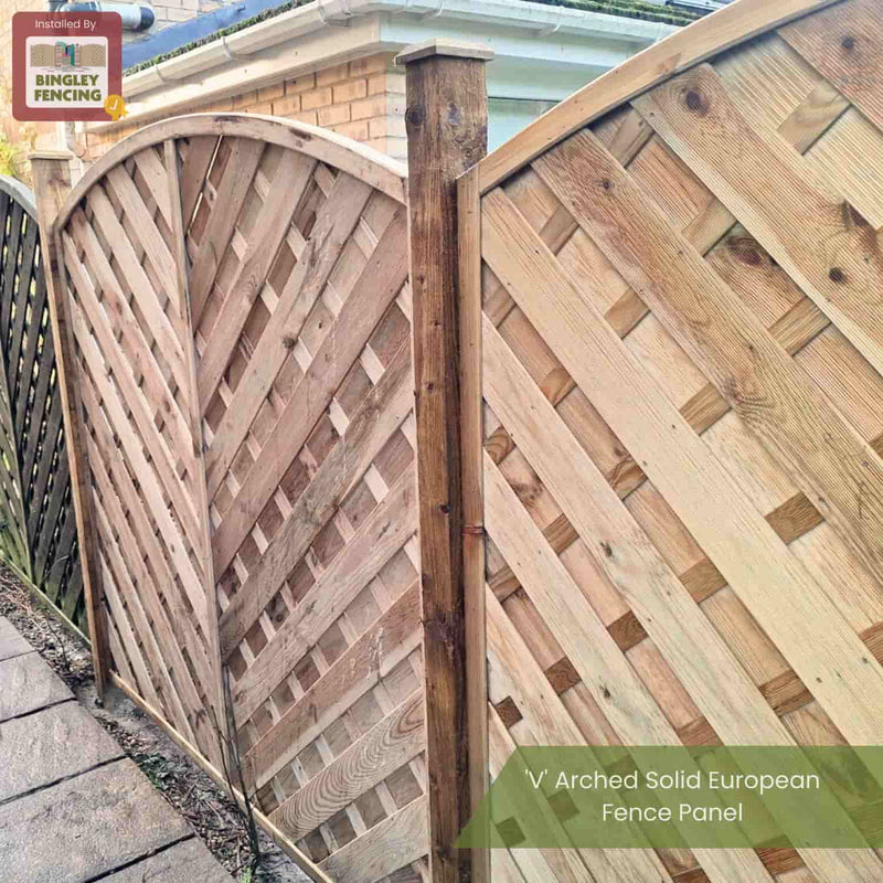 Load image into Gallery viewer, Two KDM V Arched Solid European Fence Panels with a diagonal lattice and timber post line a stone path next to a brick house. Text: “KDM V Arched Solid European Fence Panel.”.