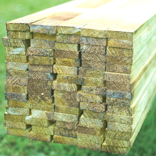 Load image into Gallery viewer, A neatly arranged stack of KDM's greenish-brown wooden beams from the Fence Panel Extension Kit is displayed outdoors. The ends show visible wood grain and slight color variations, set against a grassy background, making it ideal for a European fence panel project.