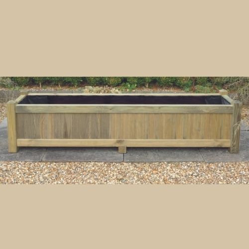 The KDM Long Rectangular Planter (LRP), with its simple, rustic design akin to European fence panels, is set on a gravel surface with lush greenery in the background.