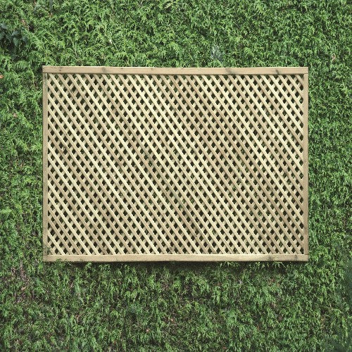 Load image into Gallery viewer, The KDM Trellis - Privacy Lattice- Rectangle 90cm x 183cm - PL10 features a crisscross pattern, mounted on a dense green foliage wall, creating a captivating grid effect ideal for garden screening.