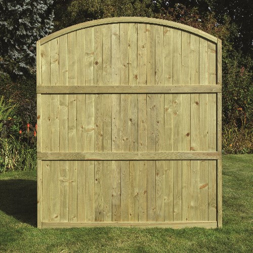 Load image into Gallery viewer, The KDM Arched Tongue & Groove Fence Panel (TGA180) features a tall, curved-top design for privacy and durability. It stands on grass with trees and garden plants in the background, and comes pressure treated for long-lasting use.