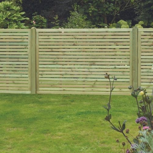 Load image into Gallery viewer, A modern slatted design created by KDM's Slatted Fence Panels graces the garden, providing privacy and security. In the foreground, green grass and various plants flourish, while trees and shrubs in the background enhance this lush, natural setting with a touch of European elegance.