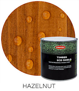 Load image into Gallery viewer, A can of Protek Timber Eco Shield - Various Colours 2.5 Ltr is positioned in front of a close-up shot of wood featuring a hazelnut stain finish. Water droplets form beads on the surface, highlighting its waterproof capabilities. The word HAZELNUT is prominently displayed below the image.