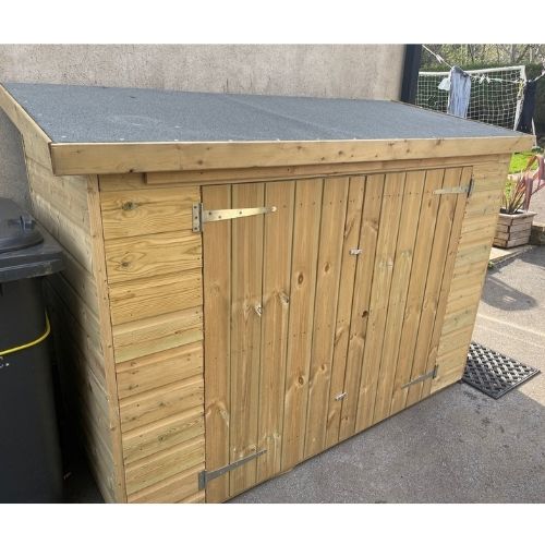 Load image into Gallery viewer, A Wooden Garden Storage with Locks by Bingley Fencing is situated on a paved area. It boasts double doors with metal hinges and a latch, making it ideal for tool storage. In the background, a soccer goal can be seen, while a recycling bin is partially visible to the left, creating both a functional and tidy garden space.