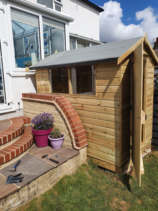 Wooden garden shed with windows and an open door