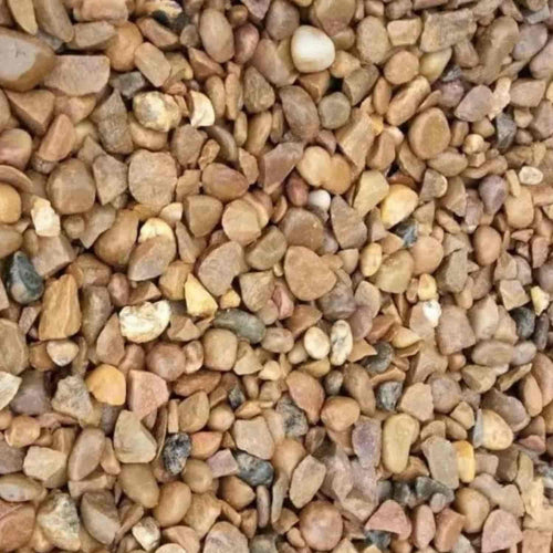 A close-up of Bingley Fencing Quartz Gravel 10mm, showing small, round and irregular pebbles in brown, tan, white, and gray hues densely covering the ground. Available in a 20kg bag for decorative aggregate use.