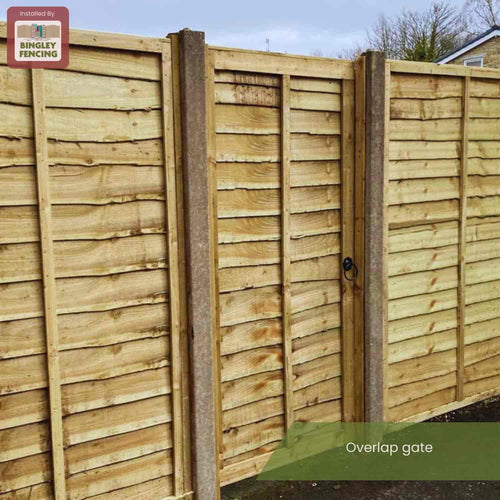 A Bingley Fencing Overlap Gate, installed between matching panels and featuring a handle, displays the brand sign in the top left corner. The text "Overlap Gate" appears at the bottom.