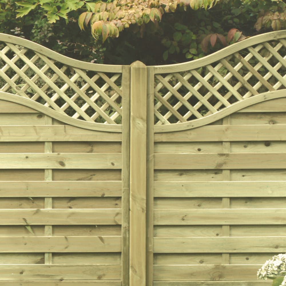 A wooden garden fence with a curved lattice top and horizontal panels below, set outdoors with green foliage in the background.