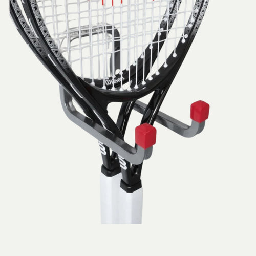 A close-up of a wall-mounted rack holding two tennis rackets with black frames and white grips. The sturdy KDM Steel Storage Hooks feature red rubber tips for safety.