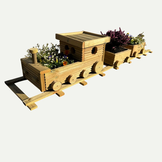 The KDM Hand Crafted Wooden Train Planter features three sections, each filled with colorful flowers and plants, sitting on a wooden track against a white background—a charming bespoke garden planter.