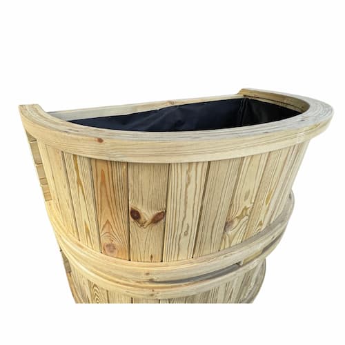 A wooden half-barrel planter with vertical planks, natural wood grain, and a black liner inside, shown against a plain white background.