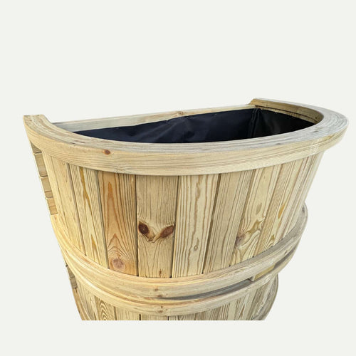 The KDM Half Moon Garden Planter - HMP is a wooden, half-barrel-shaped planter made from pressure-treated timber with visible wood grain, two horizontal bands, and a black fabric lining, shown against a plain white background.