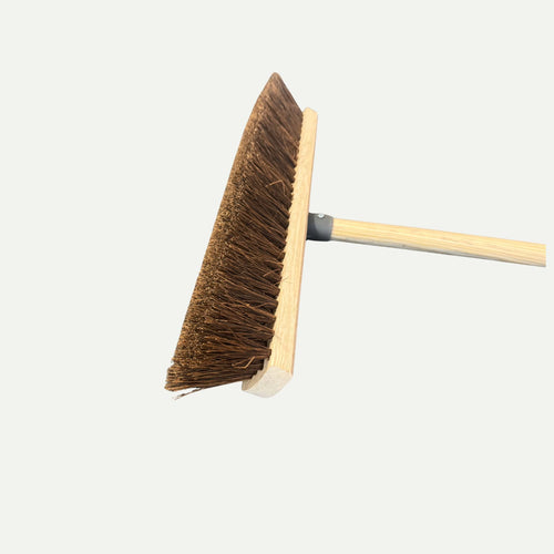 A close-up of the Bingley Fencing Hard Bristle Sweeping Brush—Various Sizes, featuring stiff brown bristles and a wooden handle, photographed against a plain white background. Multiple widths suit diverse cleaning needs.