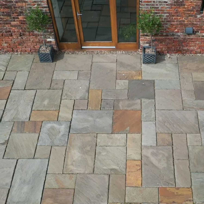 Load image into Gallery viewer, Paved patio area with a brick wall and glass door in the background
