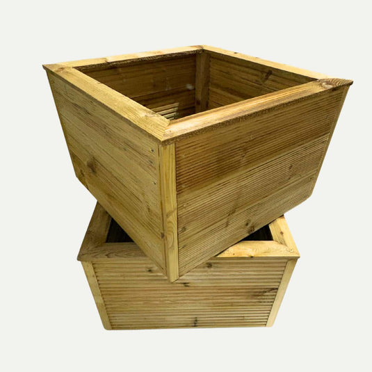 Two square “Large Square Garden Planters” by Bingley Fencing are featured, with one planter standing upright while the other rests at an angle beneath it. Both showcase a ribbed wood texture and a natural finish, making them perfect for enhancing your outdoor space.