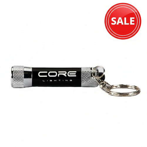 Introducing the Core Lighting Keyring Torch CLK15, a compact black LED torch featuring silver knurled ends and an attached key ring. The body proudly displays “CORE LIGHTING” in white text and offers a brightness of 15 lumens.