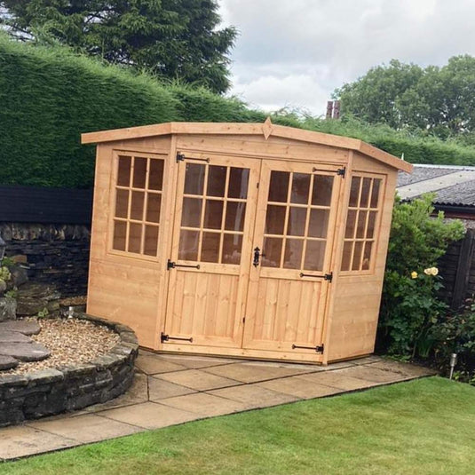 corner shaped garden summerhouse with double doors installed in a garden