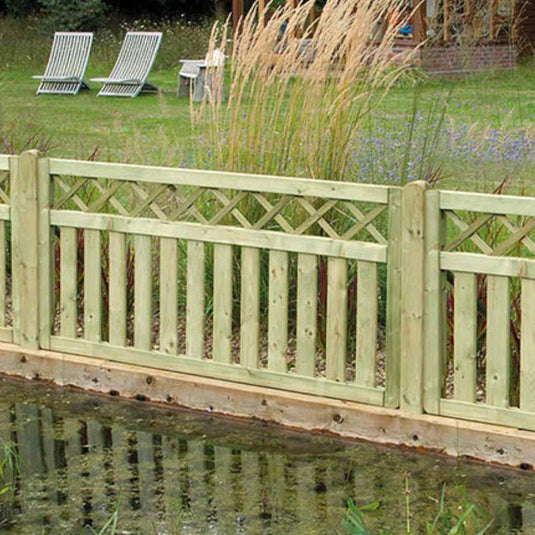 Cross Top fence and deck panel. With vertical slats and fancy lattice top. The fence panel is sat on the edge a pond in a garden.